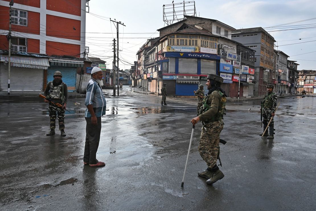 Indian security personnel question a man on a street during a curfew in Srinagar on August 8, 2019, as widespread restrictions on movement and a telecommunications blackout remained in place.