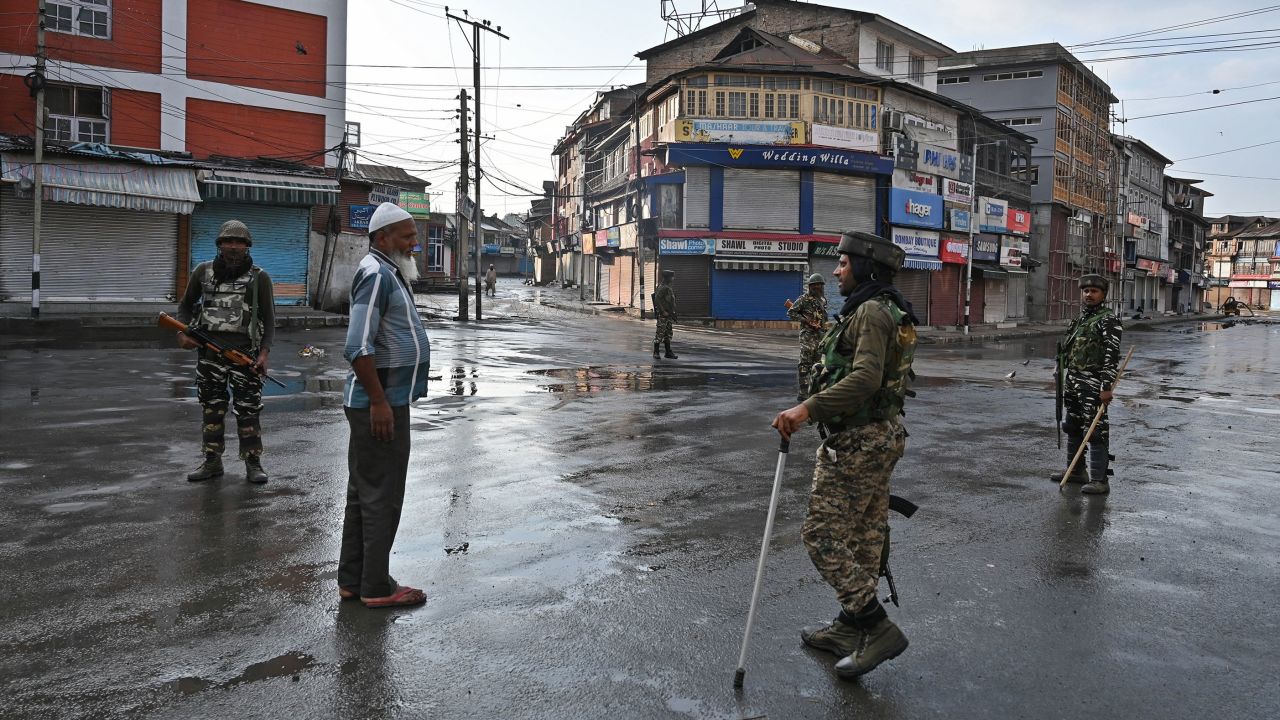 Indian security personnel question a man on a street during a curfew in Srinagar on August 8, 2019, as widespread restrictions on movement and a telecommunications blackout remained in place.