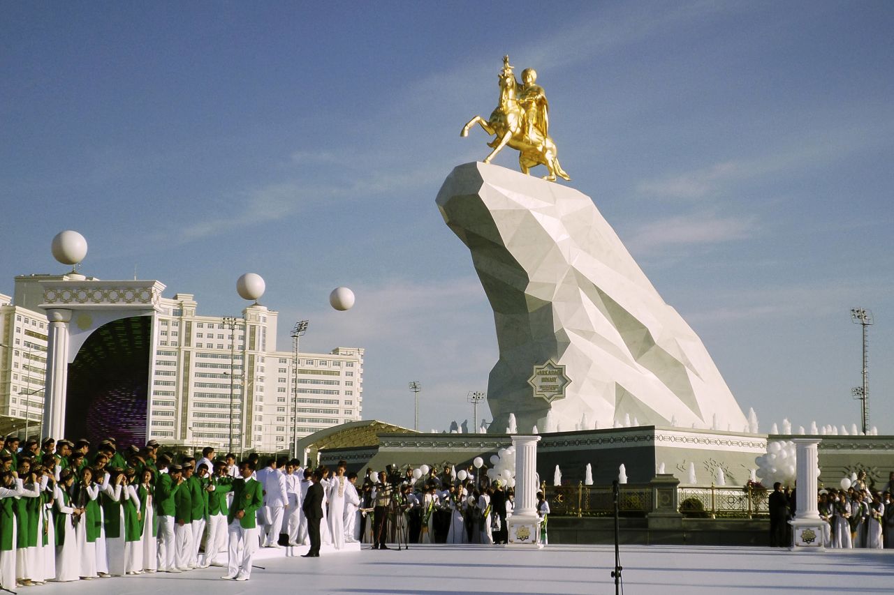 People gather for the unveiling ceremony of a 21-meter, gold-leaf statue of President Gurbanguly Berdymukhamedov atop a horse mounted on a towering pile of marble in Ashgabat, Turkmenistan, in 2015.  