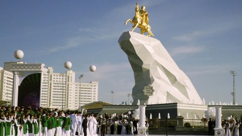 People gather for the unveiling ceremony of a 21-meter, gold-leaf statue of President Gurbanguly Berdymukhamedov atop a horse mounted on a towering pile of marble in Ashgabat, Turkmenistan, in 2015.  