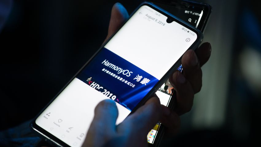 A guest holds her phone showing a picture taken during Huawei's press conference unveiling its new HarmonyOS operating system in Dongguan, Guangdong province on August 9, 2019. - Chinese telecom giant Huawei unveiled its own operating system on August 9, as it faces the threat of losing access to Android systems amid escalating US-China trade tensions. (Photo by FRED DUFOUR / AFP)        (Photo credit should read FRED DUFOUR/AFP/Getty Images)