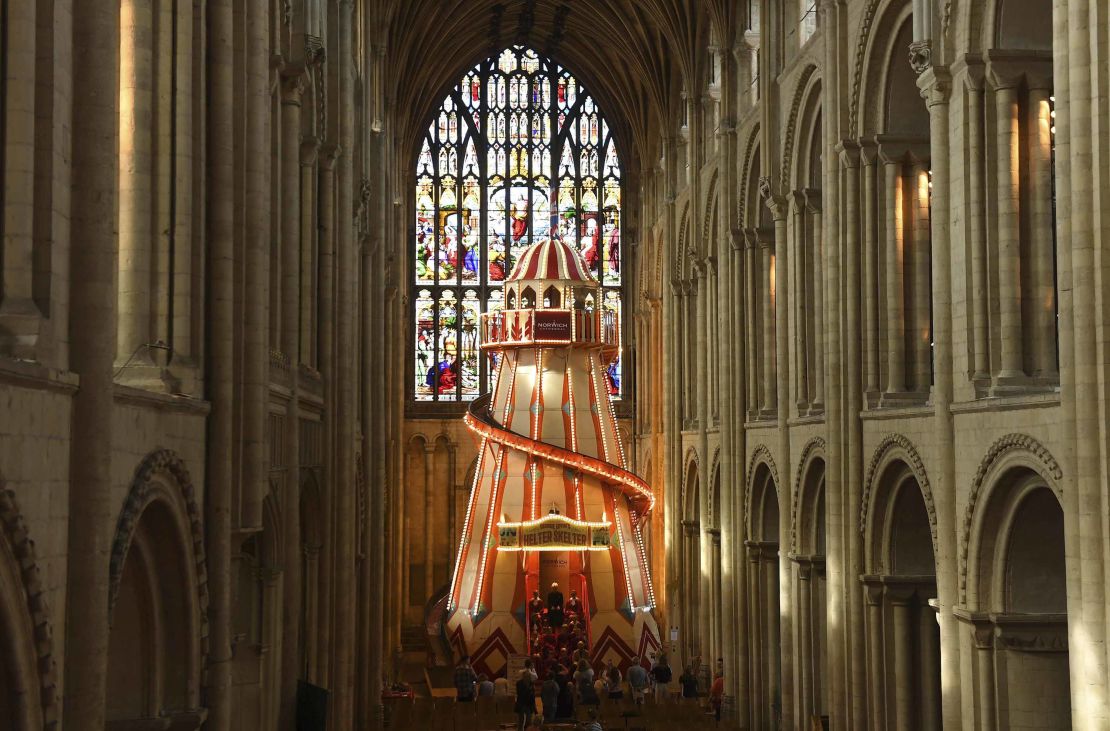 The giant ride is set up in front of a large stained glass window.