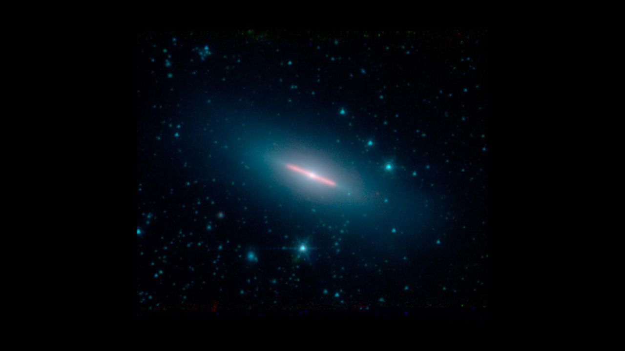 Galaxy NGC 5866 is 44 million light-years from Earth. It appears flat because we can only see its edge in this image captured by NASA's Spitzer Space Telescope.