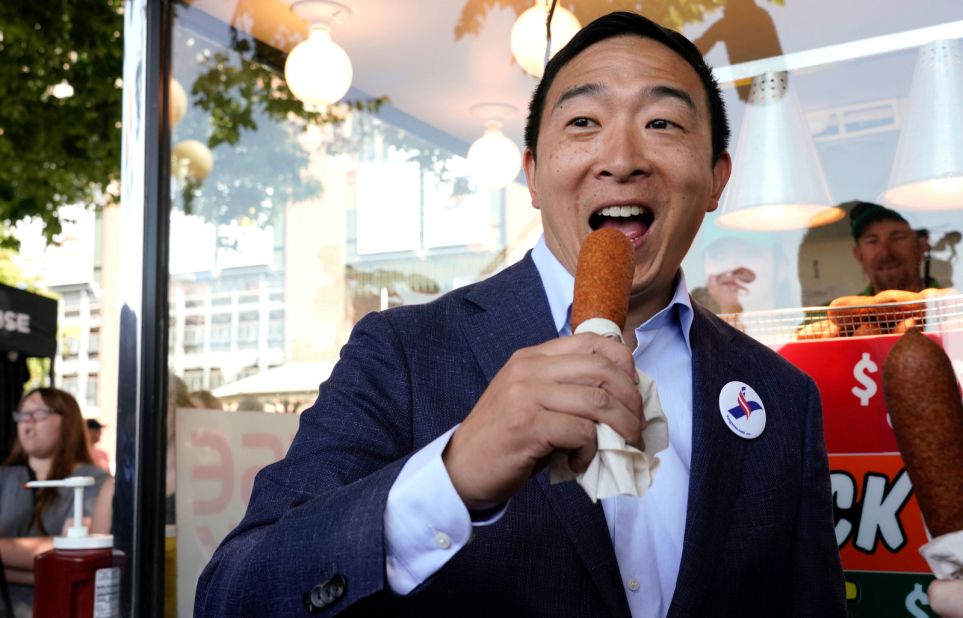 Democratic presidential candidate Andrew Yang eats a corn dog at the fair on Friday. The corn dog is just one of 69 food items <a href="https://www.iowastatefair.org/food/food-on-a-stick/" target="_blank" target="_blank">that you can find on a stick there.</a>