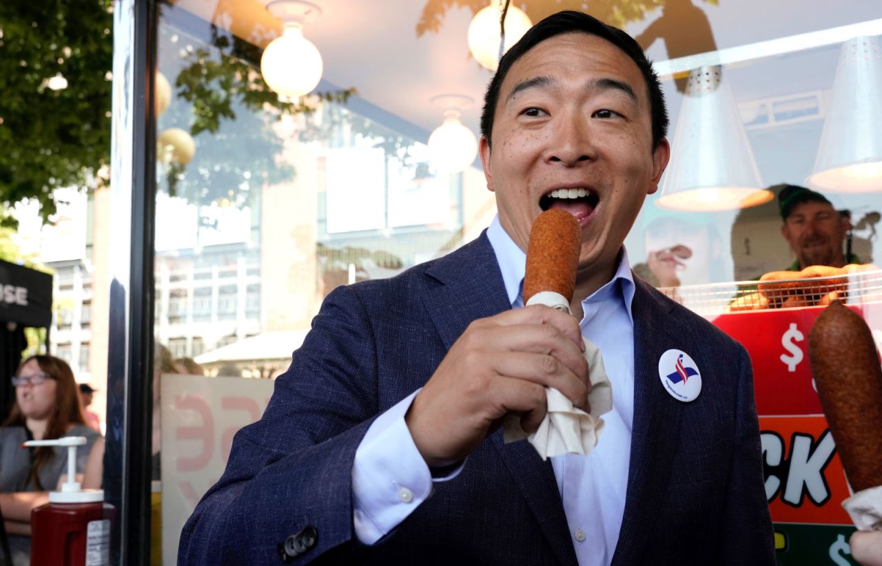 Yang enjoys a corn dog at the Iowa State Fair in August 2019.