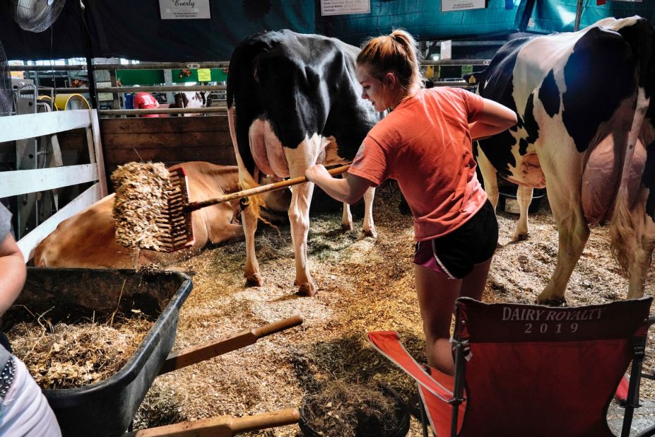 A young woman cleans the dairy barn -- an unglamorous but important job.