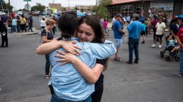 CNN reporter Nicole Chavez hugs Adria Gonzalez, a survivor of the mass shooting in El Paso, nearby a memorial, across from the Walmart where the shooting took place, in El Paso, Texas, Tuesday, Aug. 6, 2019.