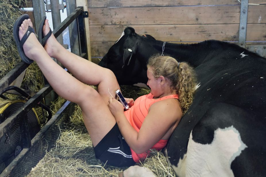A girl and her cow relax between shows.