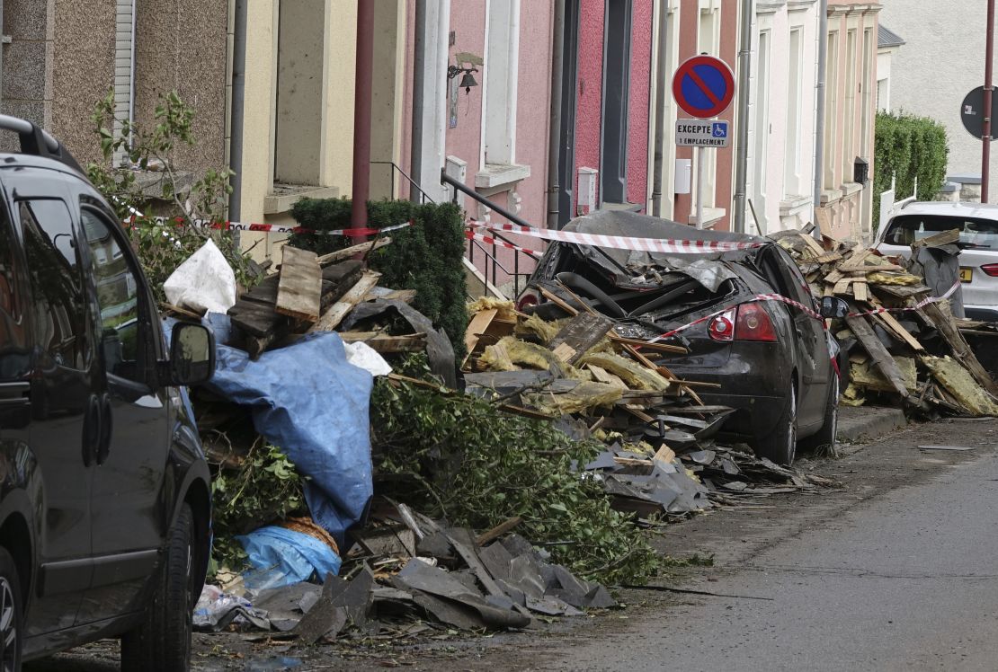 Debris and damaged cars line a road in southwestern Luxembourg after a tornado struck Friday.