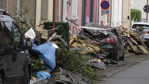 Debris and damaged cars line a road in southwestern Luxembourg after a tornado struck Friday.