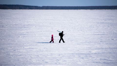 A man and his son go ice-fishing in Vaasa area, on the frozen Bothnia sea (Baltic Sea), on March 20, 2018, in Vaasa.