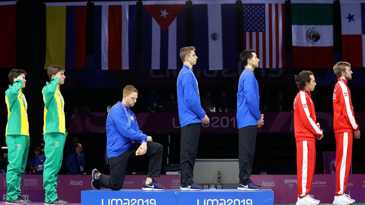LIMA, PERU - AUGUST 09: Gold medalist Race Imboden of United States  takes a knee during the National Anthem Ceremony in the podium of Fencing Men's Foil Team Gold Medal Match Match on Day 14 of Lima 2019 Pan American Games at Fencing Pavilion of Lima Convention Center on August 09, 2019 in Lima, Peru. (Photo by Leonardo Fernandez/Getty Images)