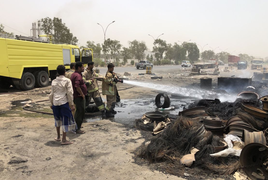 Firefighters extinguish a fire following clashes between pro-government forces and separatists in Aden on August 11, 2019.