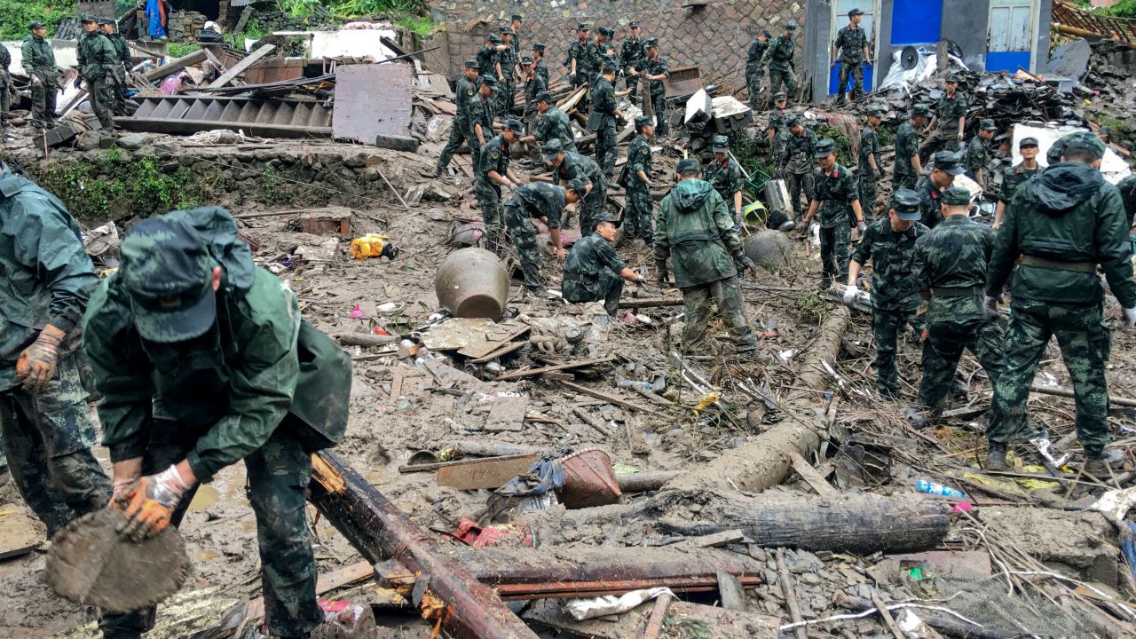 Rescuers look for survivors in the rubble of damaged buildings after a landslide in Yongjia.