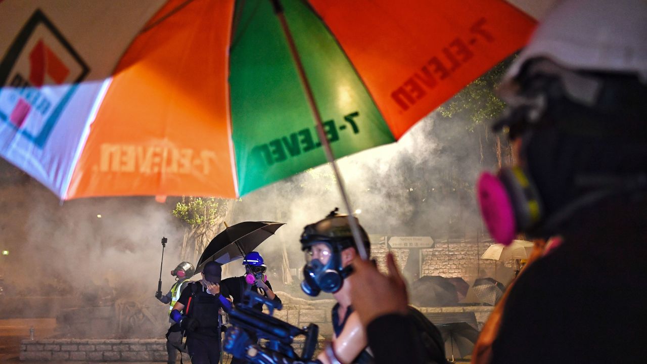 Protesters shield themselves from tear gas fired by the police.