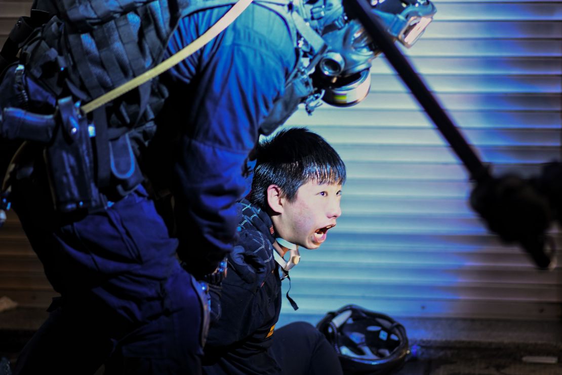 A pro-democracy protester is held by police outside Tsim Sha Tsui Police station on August 11, 2019.