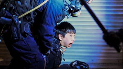 A pro-democracy protester is held by police outside Tsim Sha Tsui Police station on August 11, 2019.