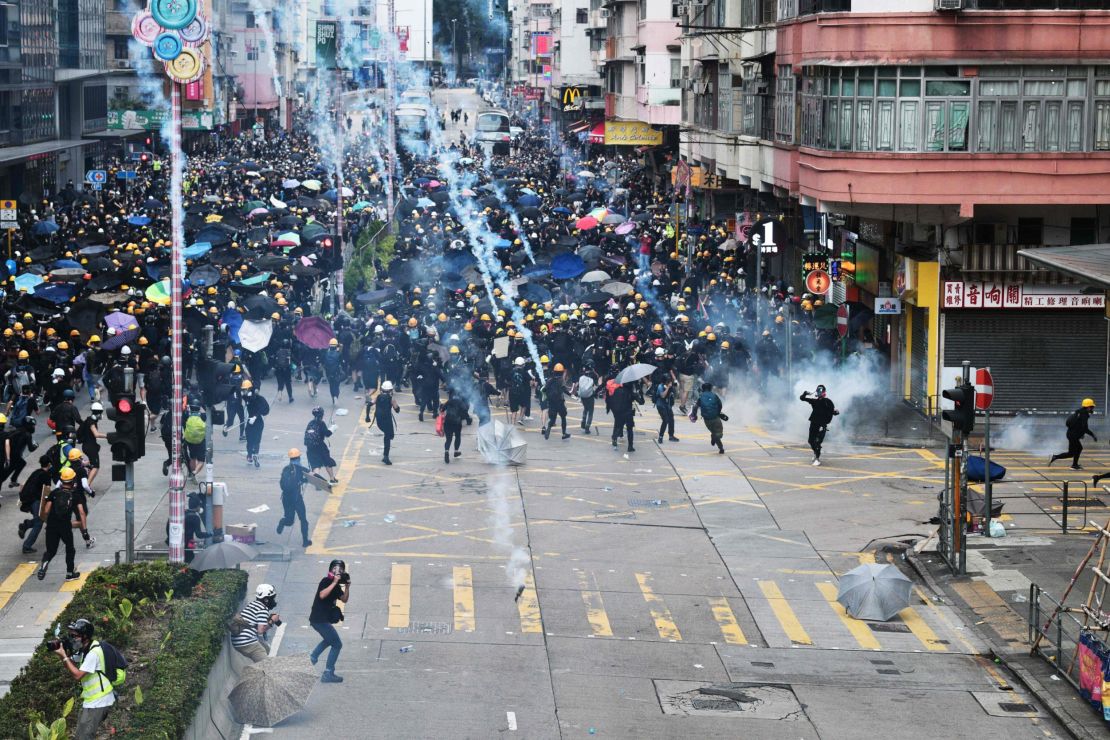 Protesters throw back tear gas fired by the police during a demonstratrion in Sham Shui Po district in Hong Kong on August 11, 2019. 