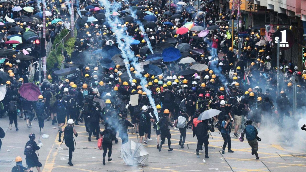 Protesters throw back tear gas fired by the police during a demonstratrion in Sham Shui Po district in Hong Kong on August 11, 2019. 