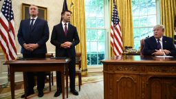 US President Donald Trump speaks to the media as Guatemalan minister of Interior and Home Affairs Enrique Degenhart (L) and Acting US Department of Homeland Security Secretary Kevin McAleenan look on after signing an asylum agreement in the Oval Office of the White House in Washington, DC on July 26, 2019. (Photo by Brendan Smialowski / AFP)   