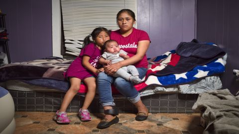 Isabella Gregorio Alonzo, 27, poses for a portrait with her daughters Juana, 7, and Angelina, 3 months, in the home she shares with other immigrants in Forest, Mississippi. Both Gregorio and her husband were detained. She was released with an ankle monitor, which can be seen on her right leg. 