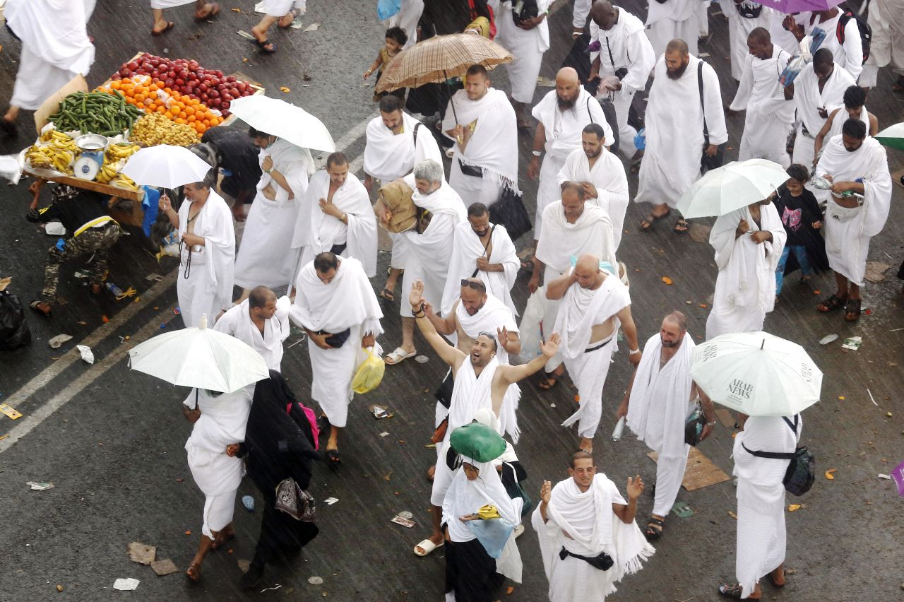 Pilgrims walk under heavy rains in Arafat on Saturday, August 10.