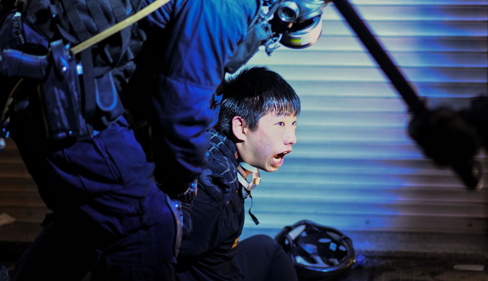 A pro-democracy protester is held by police outside the Tsim Sha Tsui police station on August 11.