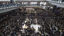 Protesters surround banners that read: "Those charge to the street on today is brave!," center top, and "Release all the detainees!" during a sit-in rally at the arrival hall of the Hong Kong International airport, Monday, Aug. 12, 2019. Hong Kong police showed off water cannons Monday as pro-democracy street protests stretched into their 10th week with no sign of either side backing down. (AP Photo/Vincent Thian)