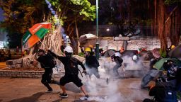 Pro-democracy protesters throw back tear gas cannisters in Tsim Sha Tsui district during a demonstration against the controversial extradition bill in Hong Kong on August 11, 2019. - Police in Hong Kong fired volleys of tear gas on August 11 at thousands of pro-democracy protesters who defied warnings from authorities to hit the streets for the tenth weekend in a row. (Photo by Manan VATSYAYANA / AFP)        (Photo credit should read MANAN VATSYAYANA/AFP/Getty Images)