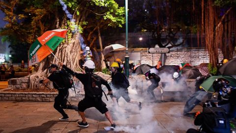 Pro-democracy protesters throw back tear gas cannisters in Tsim Sha Tsui district during a demonstration against the controversial extradition bill in Hong Kong on August 11, 2019.