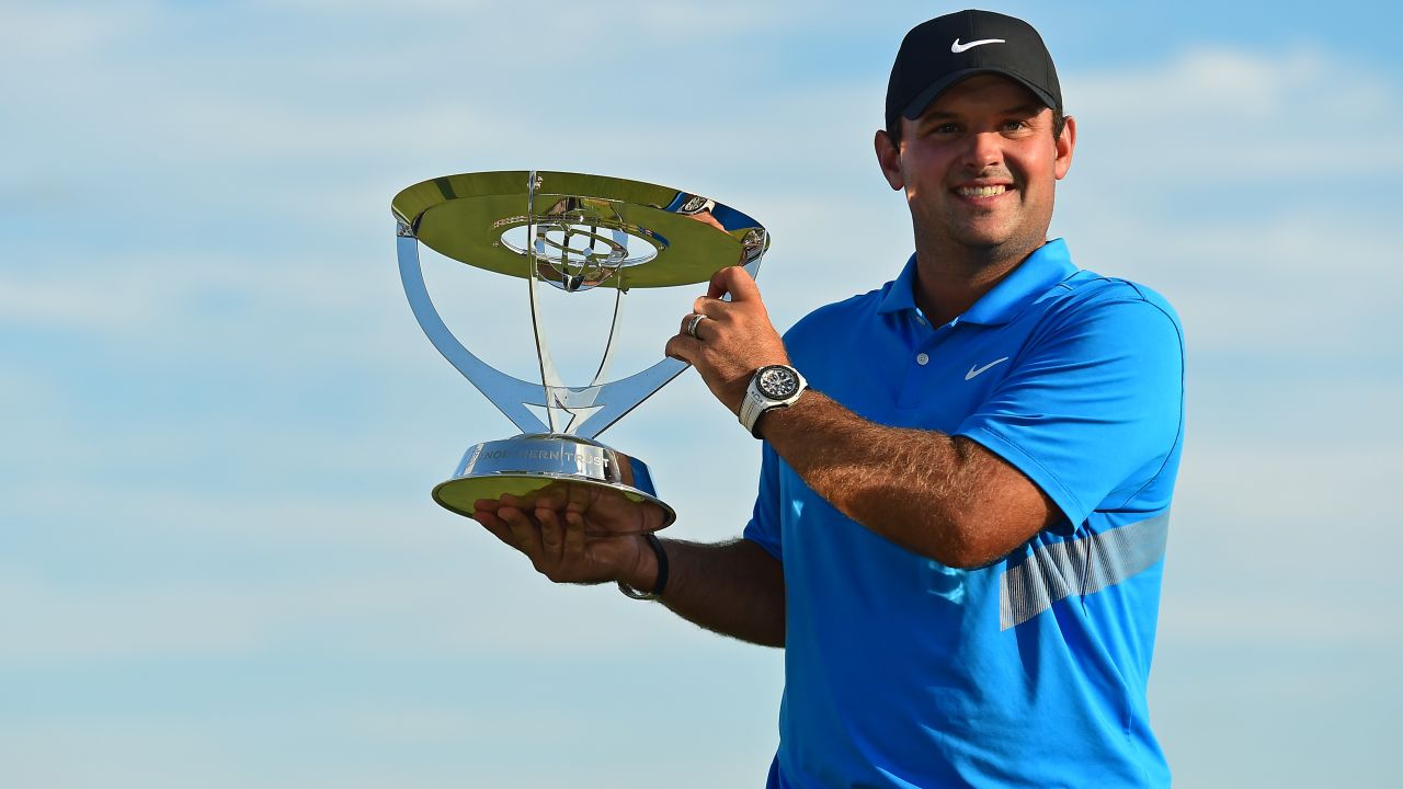 Patrick Reed celebrates with the The Northern Trust's winner's trophy.