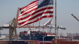 The US flag flies over a container ship unloading it's cargo from Asia, at the Port of Long Beach, California on August 1, 2019. (Photo credit should read MARK RALSTON/AFP/Getty Images)
