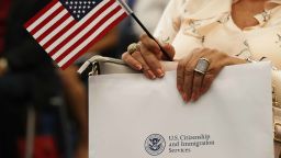 MIAMI, FL - AUGUST 17:  A person holds an American flag as they participate in a ceremony to become an American citizen during a U.S. Citizenship & Immigration Services naturalization ceremony at the Miami Field Office on August 17, 2018 in Miami, Florida. The ceremony included 141 citizenship candidates that originated from the following 33 countries: Argentina, Brazil, Bulgaria, Cameroon, Chile, Colombia, Costa Rica, Cuba, Dominican Republic, Ecuador, El Salvador,  France, Grenada, Guatemala, Haiti, Honduras, Hungry, Israel, Italy, Jamaica, Jordan, Lithuania, Mexico, Nicaragua, Nigeria, Phillippines, Slovakia, Spain, Ukraine, United Kingdom, Uruguay, Uzbekistan and Venezuela.  (Photo by Joe Raedle/Getty Images)