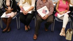 MIAMI, FL - AUGUST 17:  People hold an American flag as they participate in a ceremony to become an American citizen during a U.S. Citizenship & Immigration Services naturalization ceremony at the Miami Field Office on August 17, 2018 in Miami, Florida. The ceremony included 141 citizenship candidates that originated from the following 33 countries: Argentina, Brazil, Bulgaria, Cameroon, Chile, Colombia, Costa Rica, Cuba, Dominican Republic, Ecuador, El Salvador,  France, Grenada, Guatemala, Haiti, Honduras, Hungry, Israel, Italy, Jamaica, Jordan, Lithuania, Mexico, Nicaragua, Nigeria, Phillippines, Slovakia, Spain, Ukraine, United Kingdom, Uruguay, Uzbekistan and Venezuela.  (Photo by Joe Raedle/Getty Images)