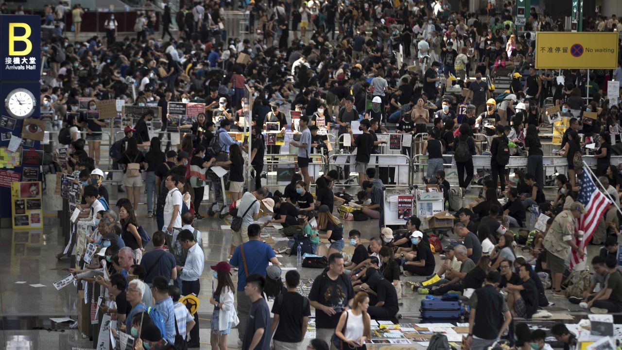 Protesters stage a sit-in rally at the arrival hall of the Hong Kong International Airport in Hong Kong, Tuesday, Aug. 13, 2019. Protesters clogged the departure area at Hong Kong's reopened airport Tuesday, a day after they forced one of the world's busiest transport hubs to shut down entirely amid their calls for an independent inquiry into alleged police abuse. (AP Photo/Vincent Thian)