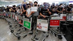 Anti-government protesters stand at a barricade made of trolleys during a demonstration at Hong Kong Airport, China August 13, 2019. REUTERS/Issei Kato