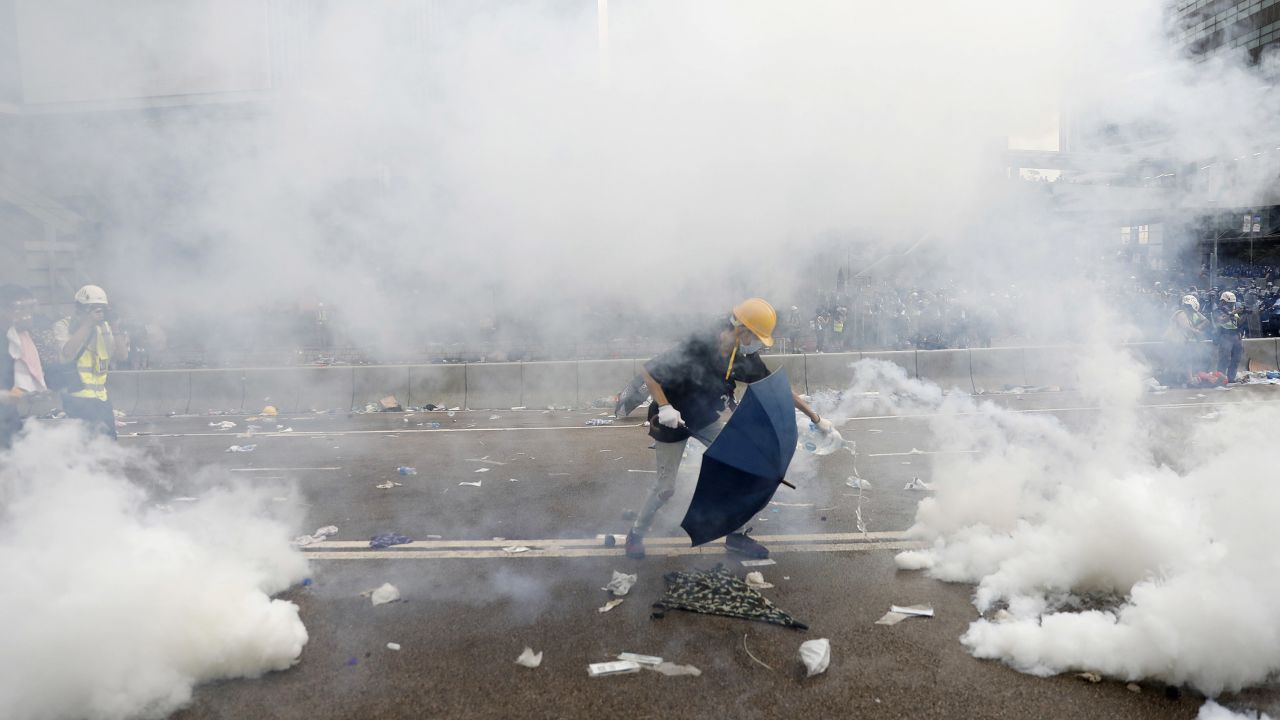 A protester douses a tear gas canister with water outside the Legislative Council during a protest against a proposed extradition law in Hong Kong, China. 