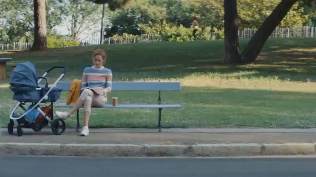 In the Volkswagen ad, a woman is shown sitting by a stroller.