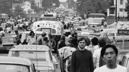 Members of the American youth subculture generally termed 'hippies' walk along roads choked with traffic on the way to the large rock conert called Woodstock, Bethel, New York, August, 1969. Sometimes likeminded motorists give them rides in or on their vehicles. (Photo by Hulton Archive/Getty Images)