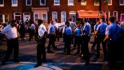 Officers gather for crowd control near a massive police presence set up outside a house as they investigate an active shooting situation, in Philadelphia, Wednesday, Aug. 14, 2019. (AP Photo/Matt Rourke)
