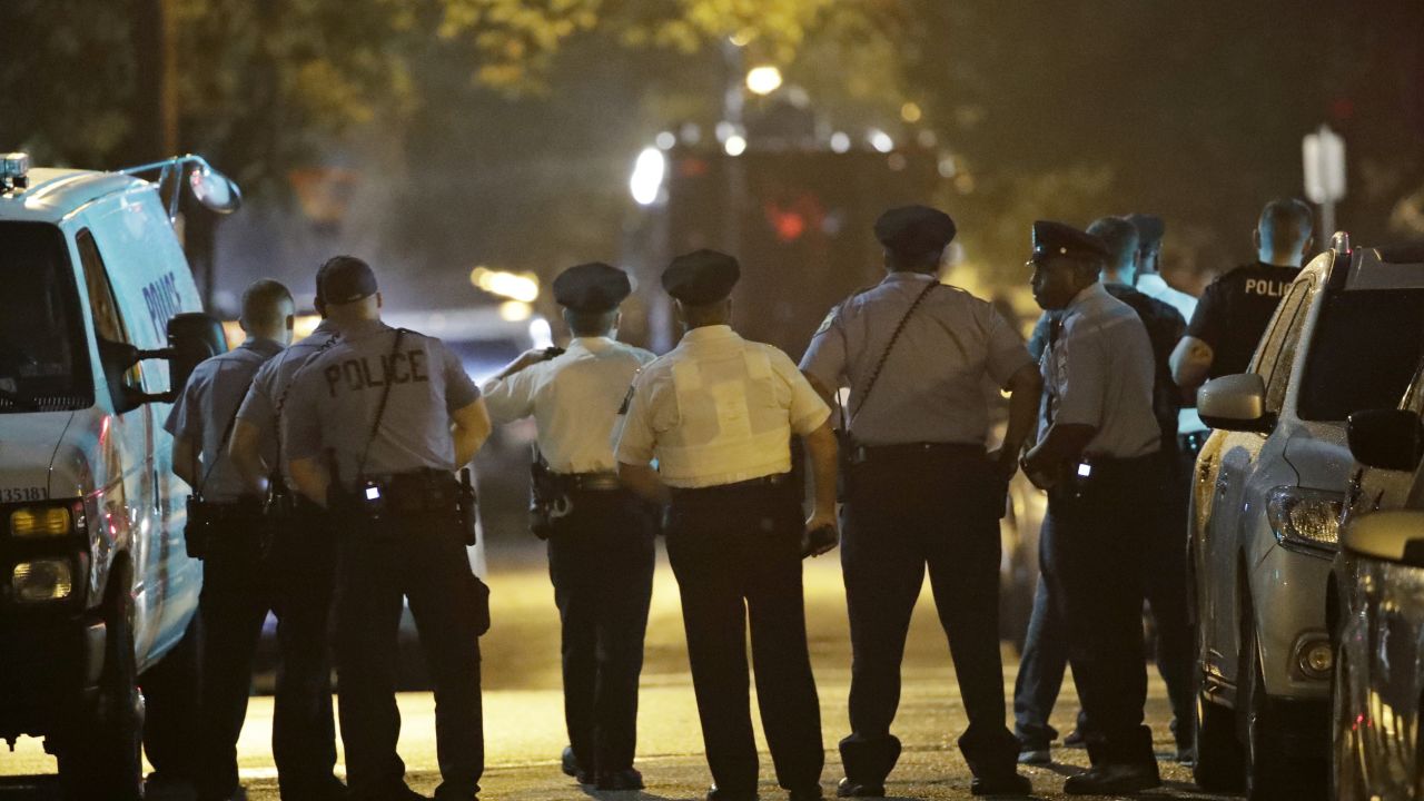 Police officers watch as a gunman is apprehended following a standoff Wednesday night.