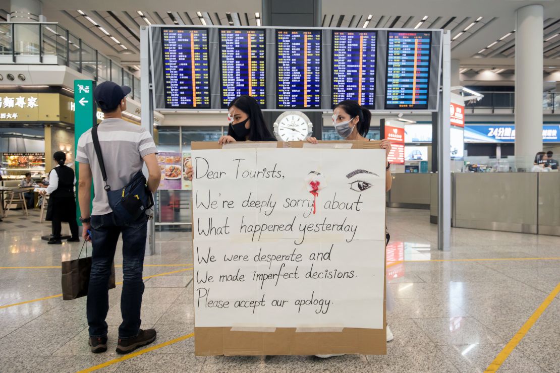 Demonstrators hold a sign at the Hong Kong International Airport in Hong Kong, China, on Wednesday, Aug. 14, 2019.