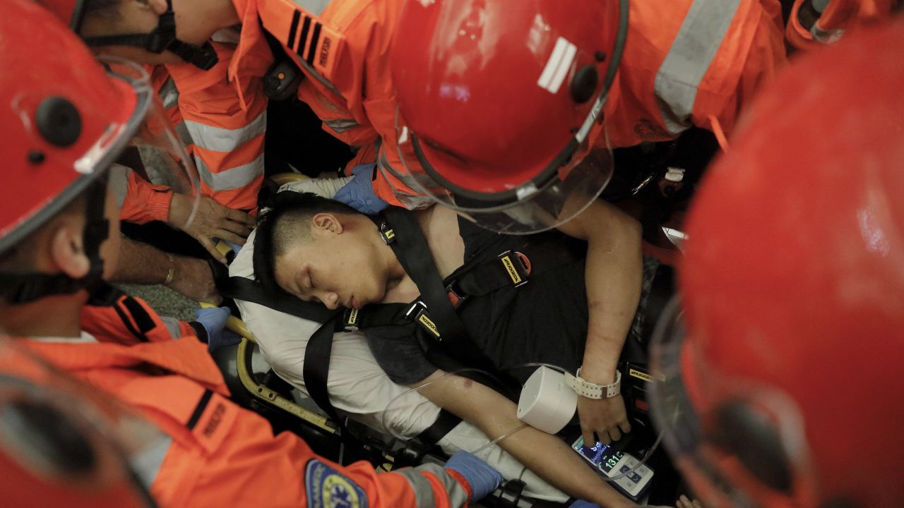 Medical staffs carry a detained man, who protesters claimed was a police officer from mainland China, during a demonstration at the Airport in Hong Kong, Tuesday, Aug. 13, 2019. Riot police clashed with pro-democracy protesters at Hong Kong's airport late Tuesday night, a chaotic end to a second day of demonstrations that caused mass flight cancellations at the Chinese city's busy transport hub. (AP Photo/Vincent Yu)