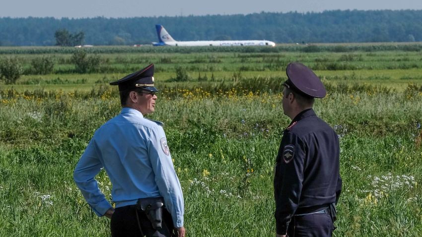 Police officers stand guard near the site of hard landing of the Ural Airlines A321 plane on a corn field near Moscow's Zhukovsky airport on August 15, 2019. - A Russian pilot was being hailed as a hero on August 15, 2019 for landing an Airbus carrying more than 230 people in a Moscow corn field after a bird strike. (Photo by Yuri KADOBNOV / AFP)        (Photo credit should read YURI KADOBNOV/AFP/Getty Images)