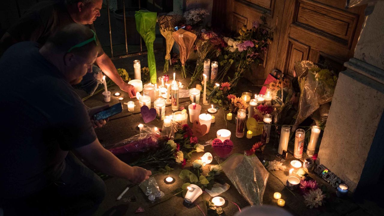 Two men light candles at a makeshift memorial as they take part of a candle lit vigil in honor of those who lost their lives or were wounded in a shooting in Dayton, Ohio on August 4, 2019. - (Photo by Megan JELINGER / AFP) (Photo credit should read MEGAN JELINGER/AFP/Getty Images)