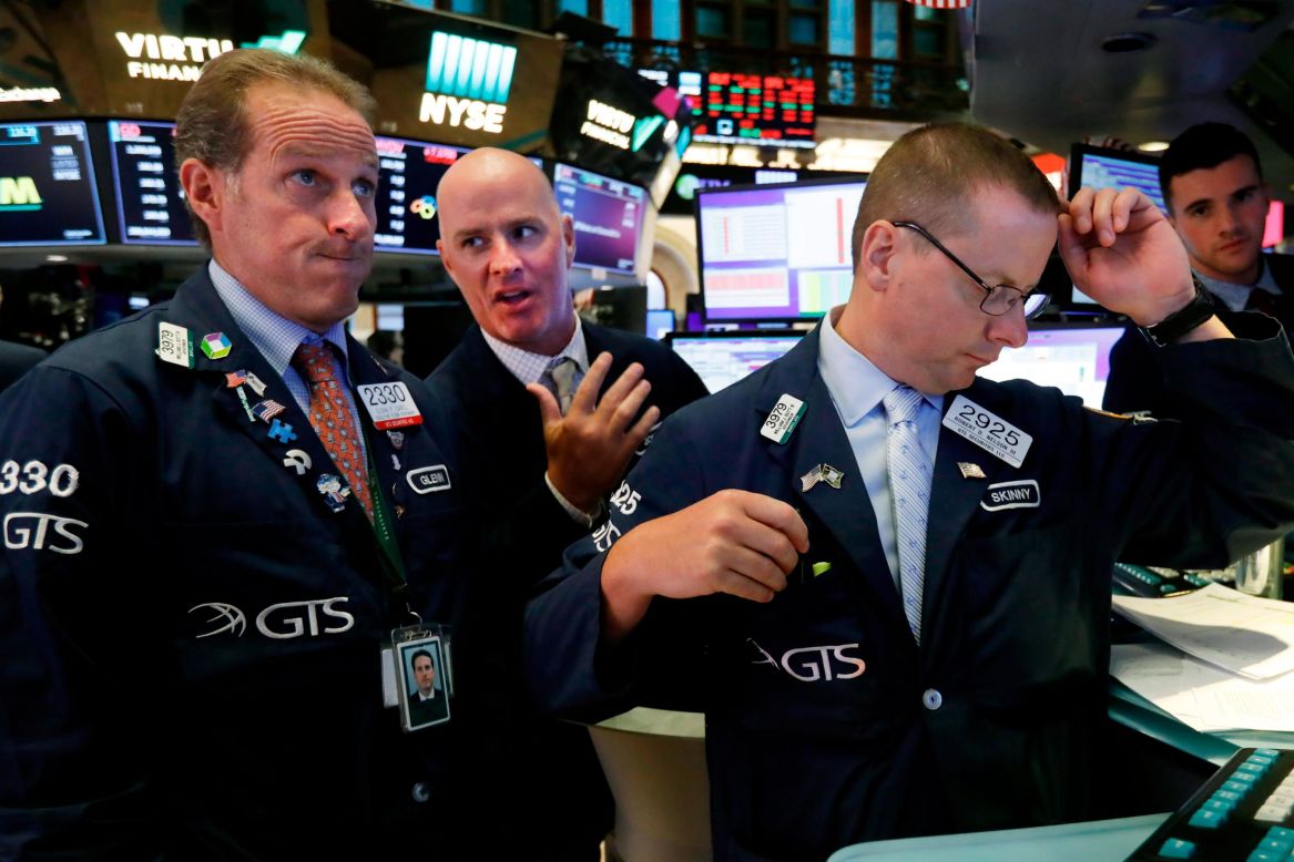 From left, specialists Glenn Carell, John O'Hara and Robert Nelson gather at a trading post on the floor of the New York Stock Exchange on Wednesday, August 14. <a href="https://www.cnn.com/2019/08/15/investing/dow-stock-market-today/index.html" target="_blank">The Dow fell 800 points</a> on Wednesday, which is the worst day of 2019 so far.