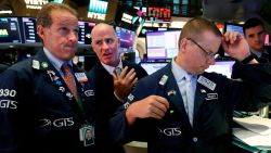 Specialists Glenn Carell, left, John 'Hara, center, and Robert Nelson, gather at a trading post on the floor of the New York Stock Exchange, Wednesday, Aug. 14, 2019. The Dow Jones Industrial Average sank 800 points after the bond market flashed a warning sign about a possible recession for the first time since 2007. (AP Photo/Richard Drew)