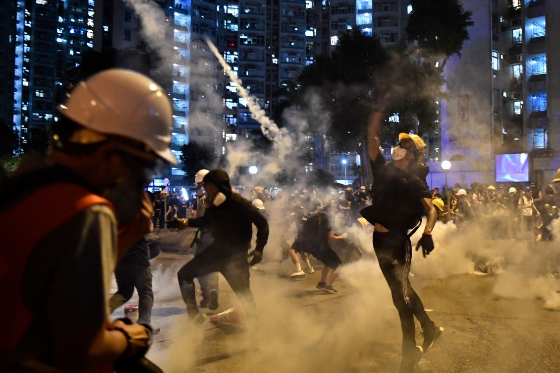 Protesters throw back tear gas fired by the police in Wong Tai Sin during a general strike in Hong Kong on August 5, 2019. 