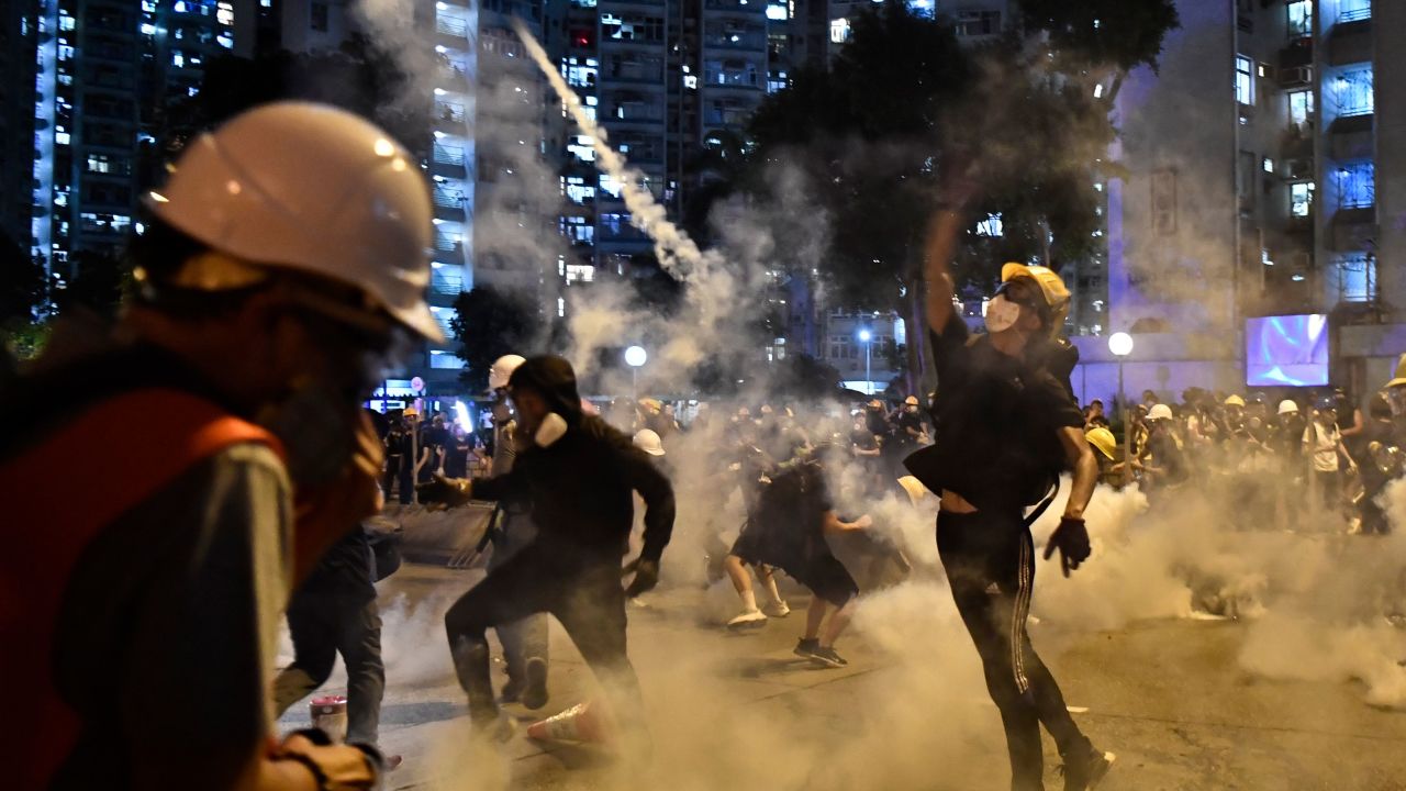 Protesters throw back tear gas fired by the police in Wong Tai Sin during a general strike in Hong Kong on August 5, 2019. 