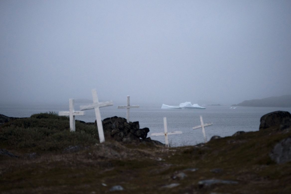 An iceberg floats near a cemetery in Kulusuk, Greenland, on Thursday, August 15. Greenland's ice sheet usually melts during the summer, but the melt season typically begins around the end of May. This year, <a href="https://www.cnn.com/2019/08/02/world/greenland-ice-sheet-11-billion-intl/index.html" target="_blank">it began at the start.</a>